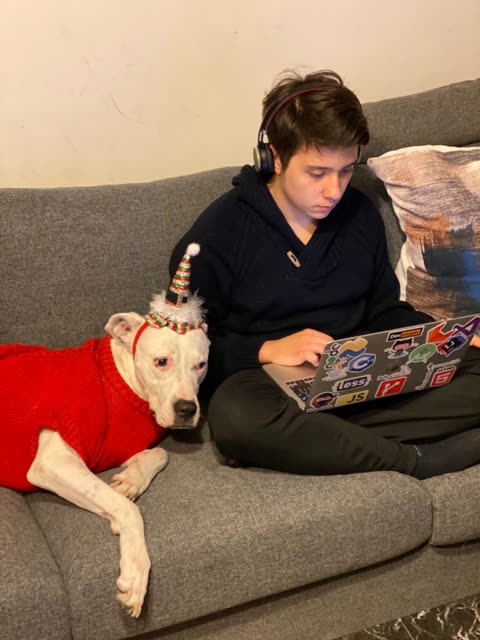 Göktürk coding on the sofa with his dog during high school.