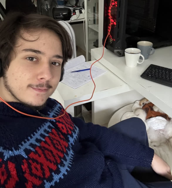 Göktürk at his desk while developing Stylingmate, with his dog nearby.